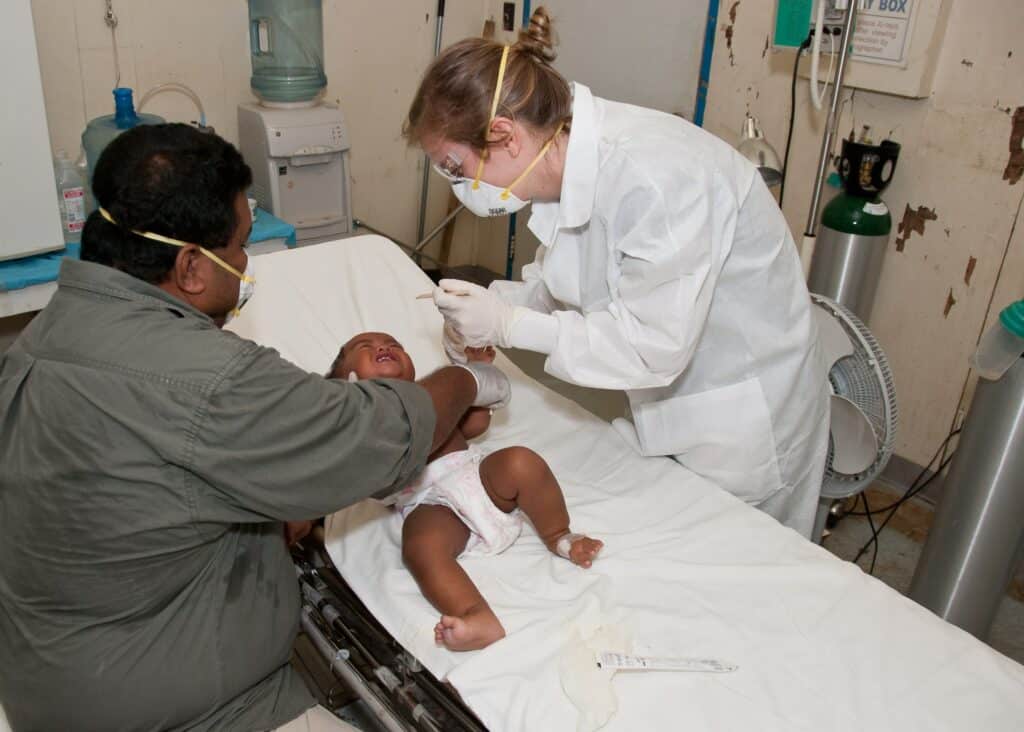 Sick baby being examined by a doctor