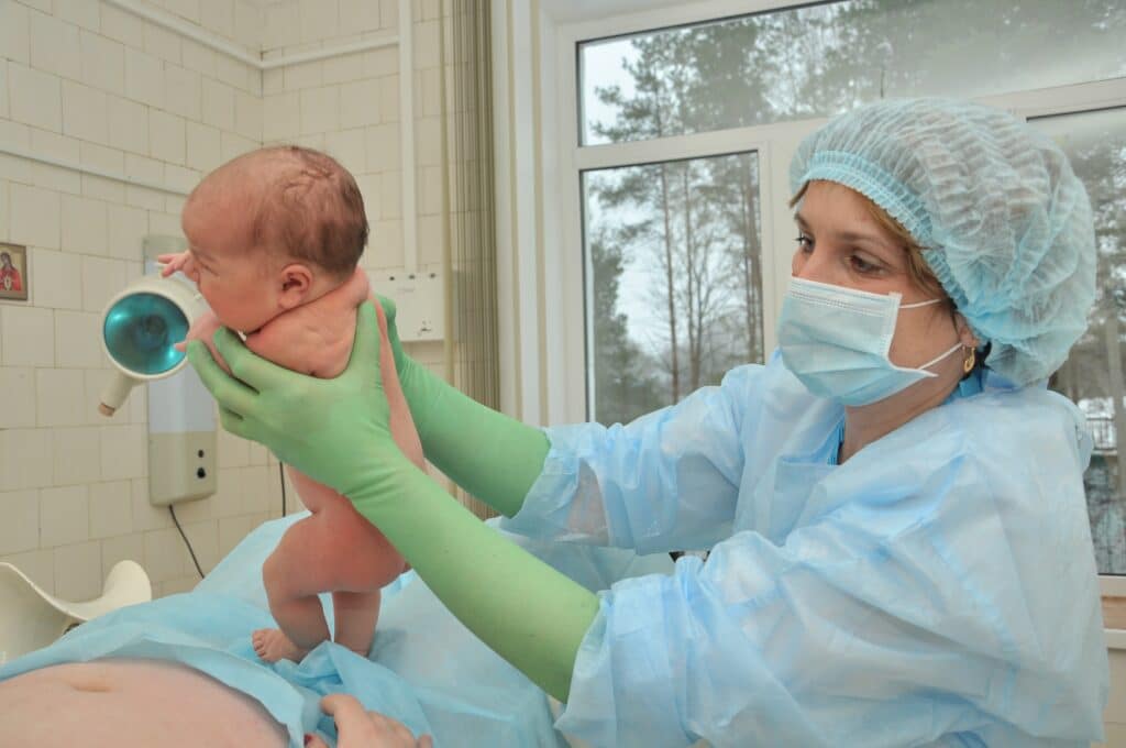 Newborn baby being presented by a doctor