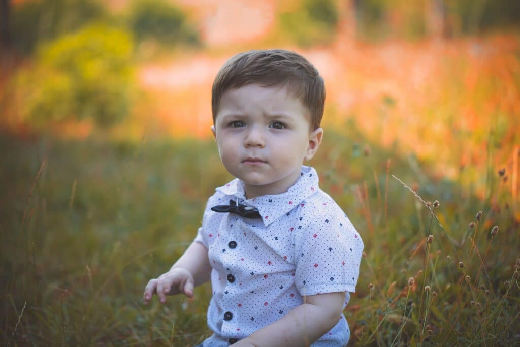 Toddler boy standing in a field