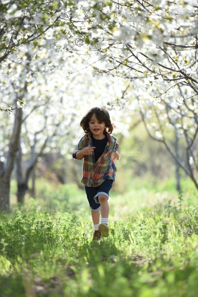 Little boy running through a forest