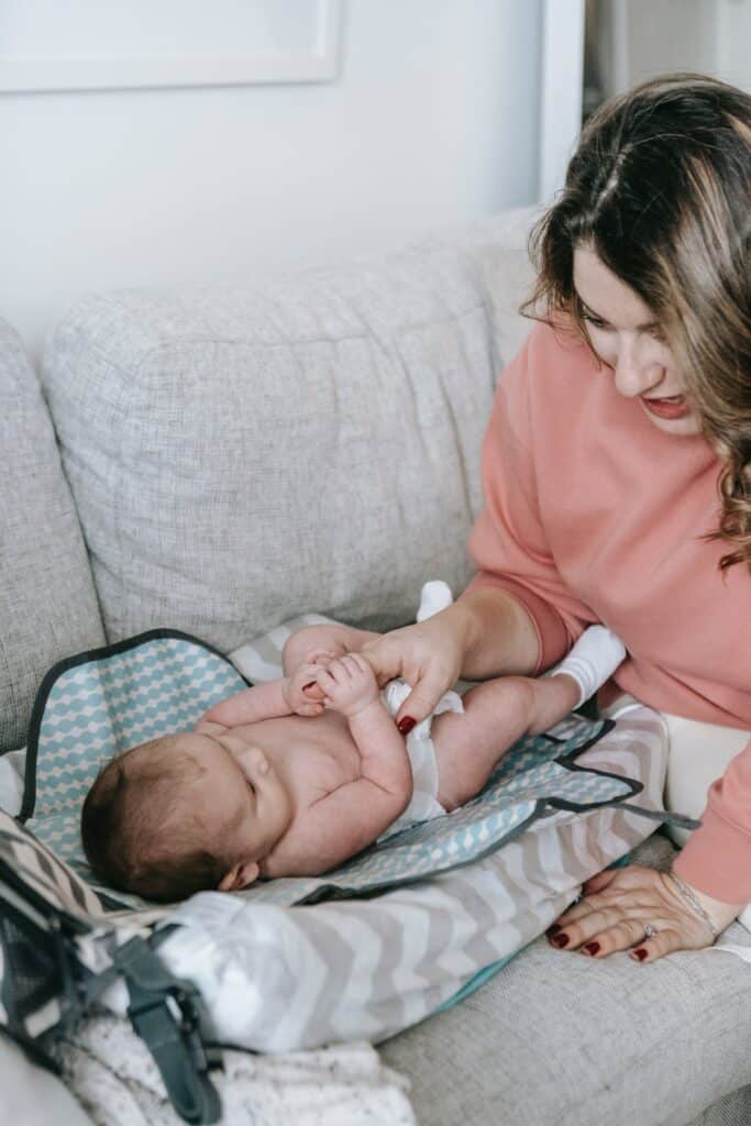 Mother changing a newborn baby's diaper