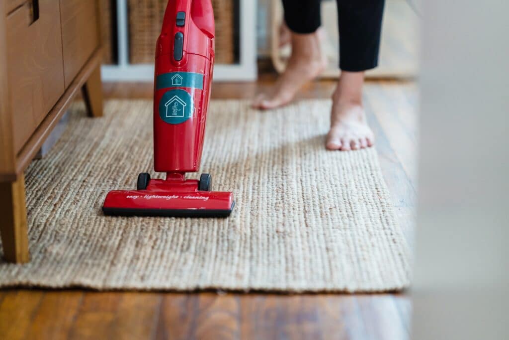 Woman cleaning carpet with vacuum
