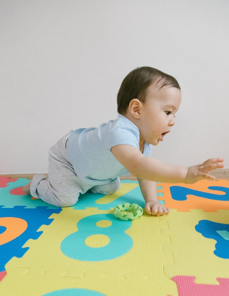 Baby crawling on a foam play mat