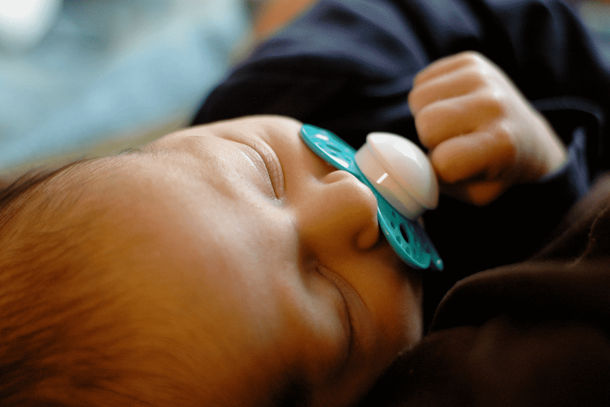 baby taking a pacifier calmly while sleeping