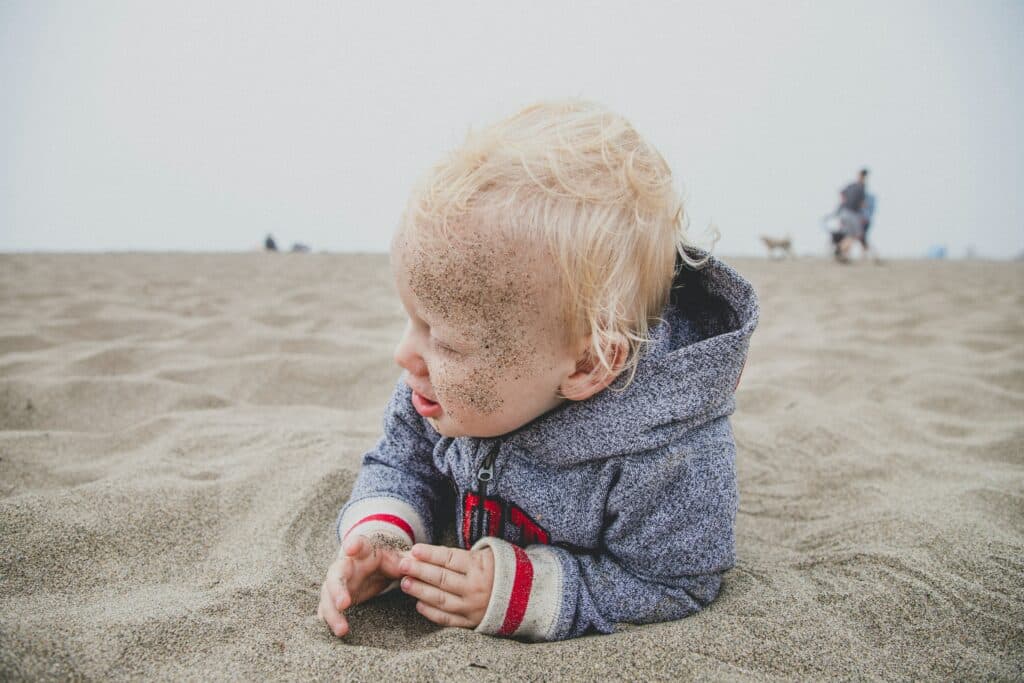 Baby laying in sand on the beach