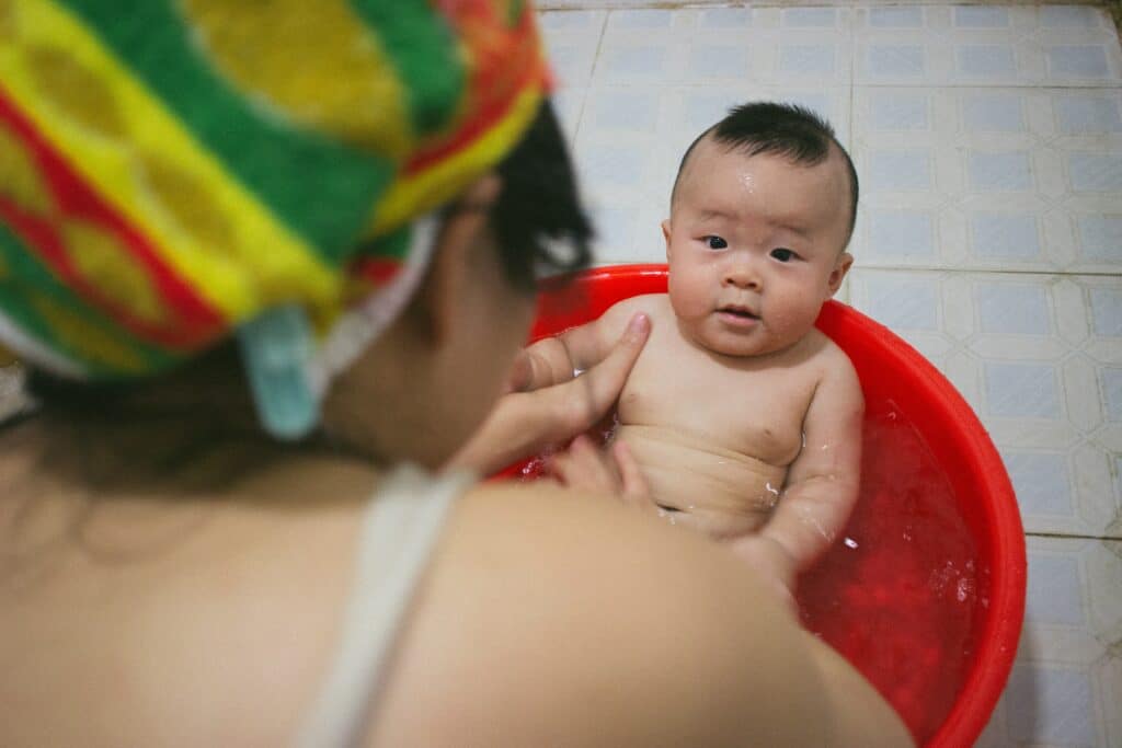 Mom bathing baby in a tub