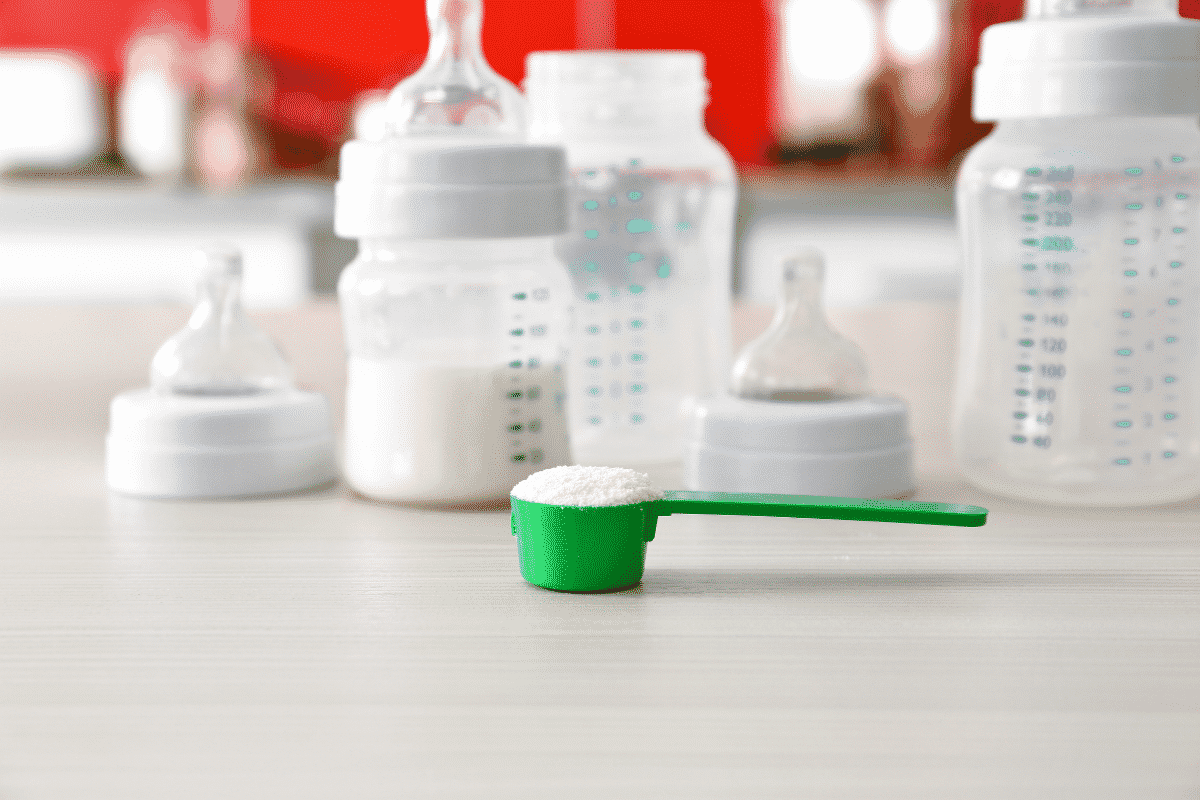 Measuring scoop with formula and baby bottles