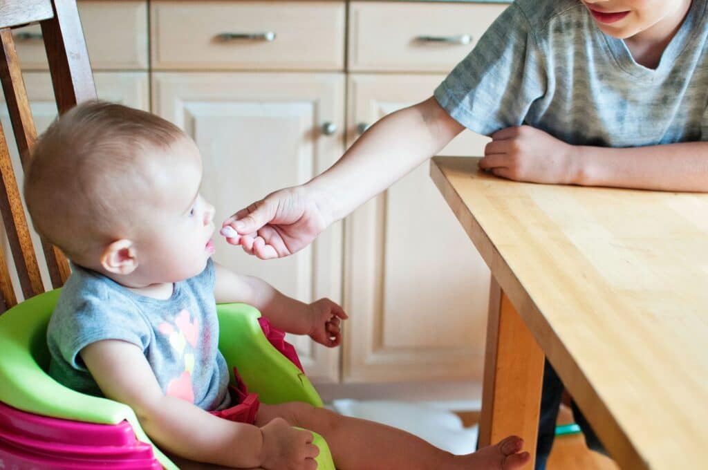 Baby eating food at table
