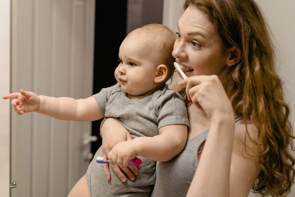 Mom brushing her teeth with baby