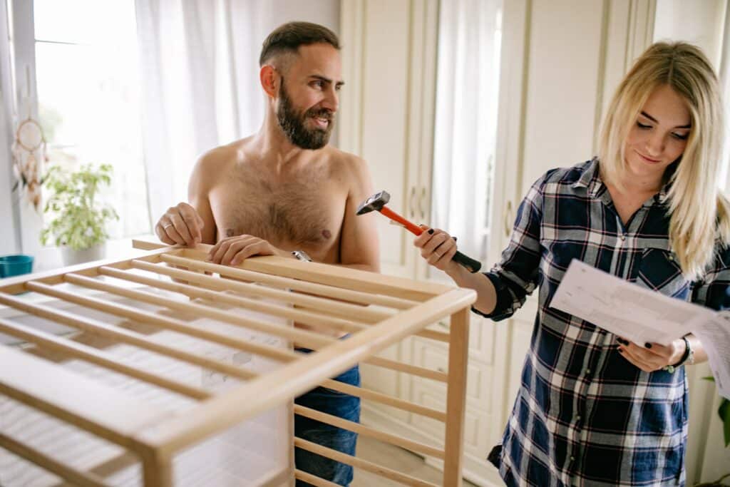 Man and woman putting a baby crib together