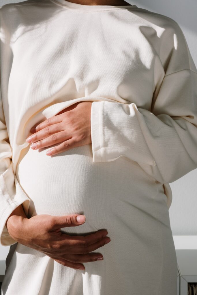 Pregnant person holding her stomach