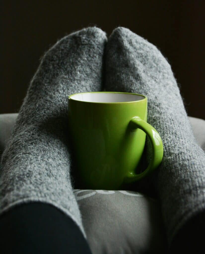 Person elevating their feet with a hot drink