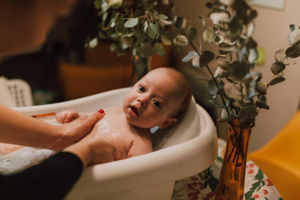 Mom giving baby a bath in the tub