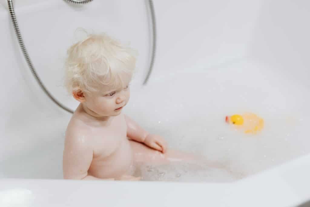 Baby taking bath with rubber duck