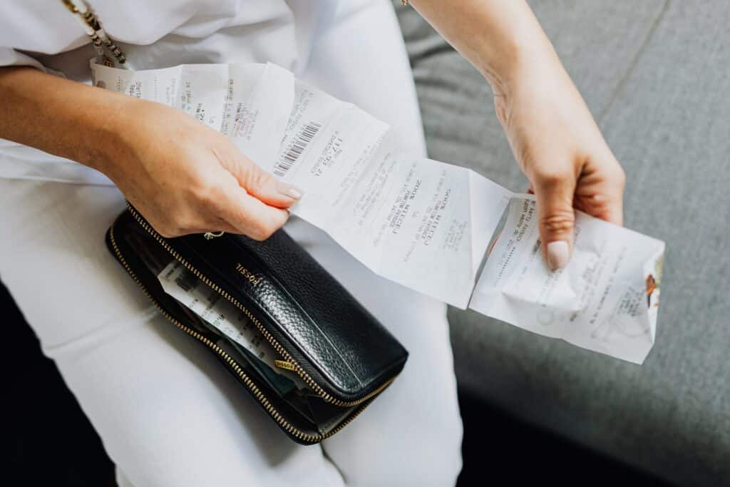 Woman holding receipt and wallet in her lap