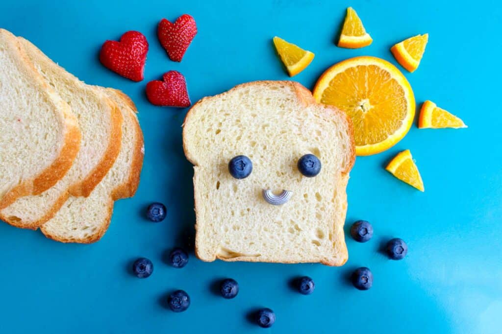 Smiley face toast made with blueberries, strawberries, and oranges