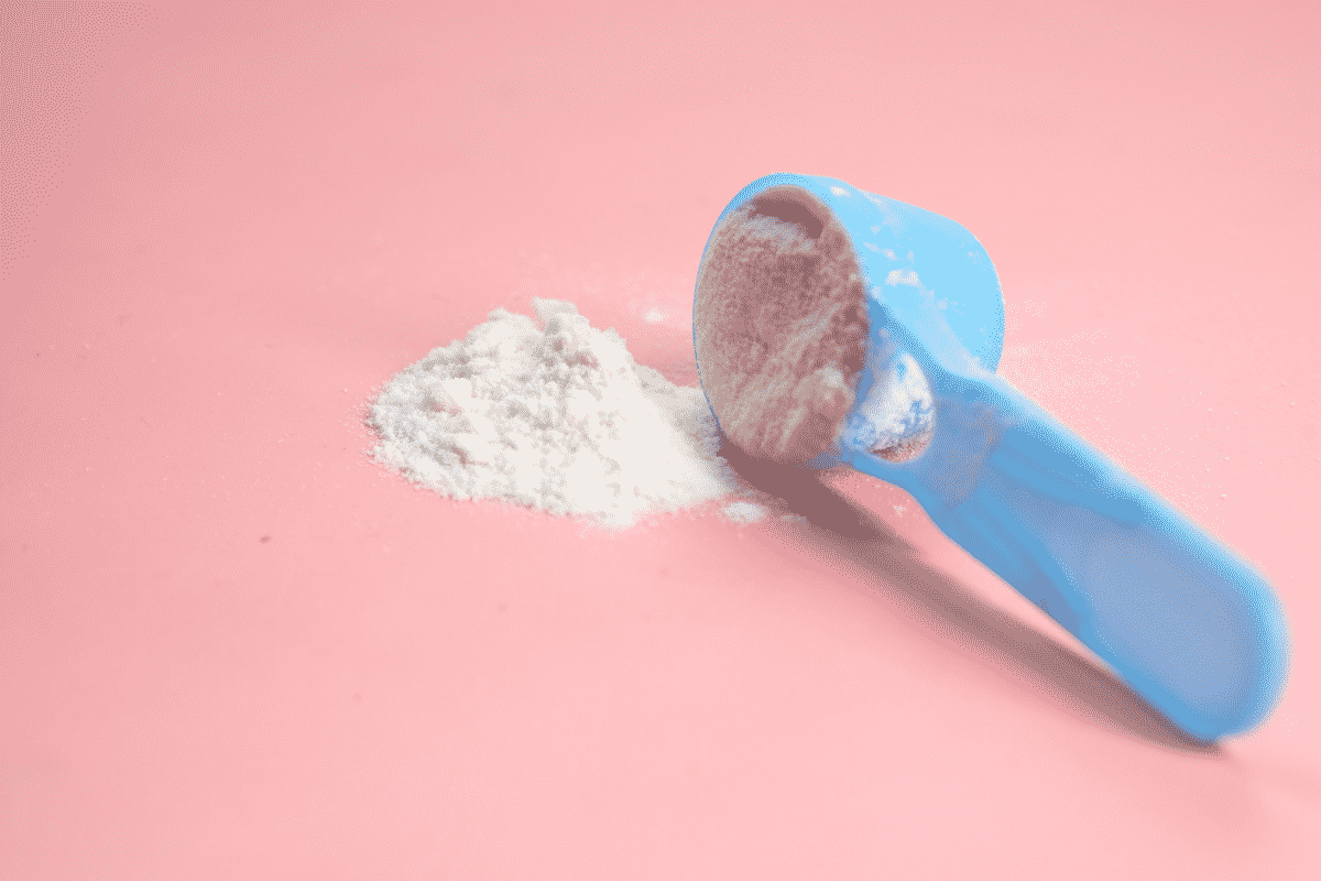 a blue scoop of baby formula on a pink table