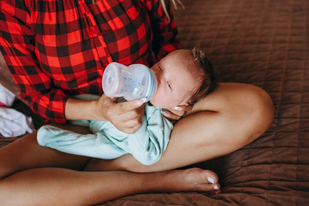 Mom feeding baby in her lap with a bottle