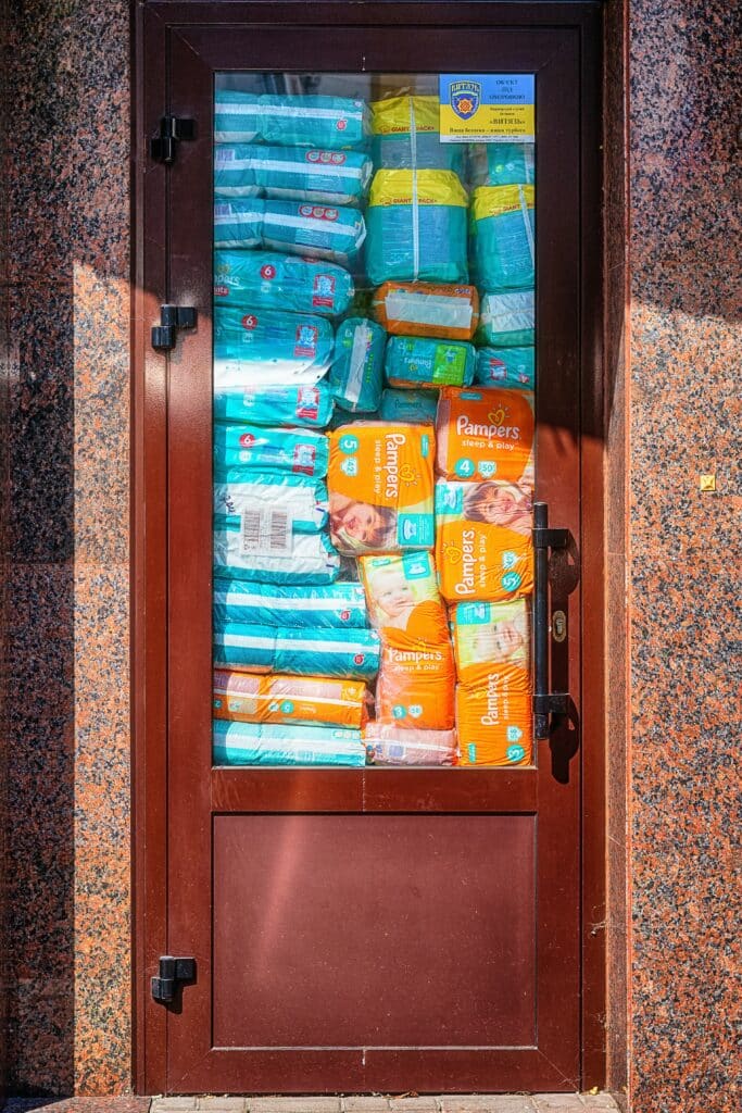 Giant stash of baby diapers ready to burst out of a glass door