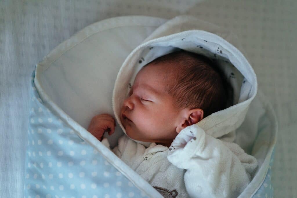 Newborn baby sleeping peacefully while wrapped in a blanket