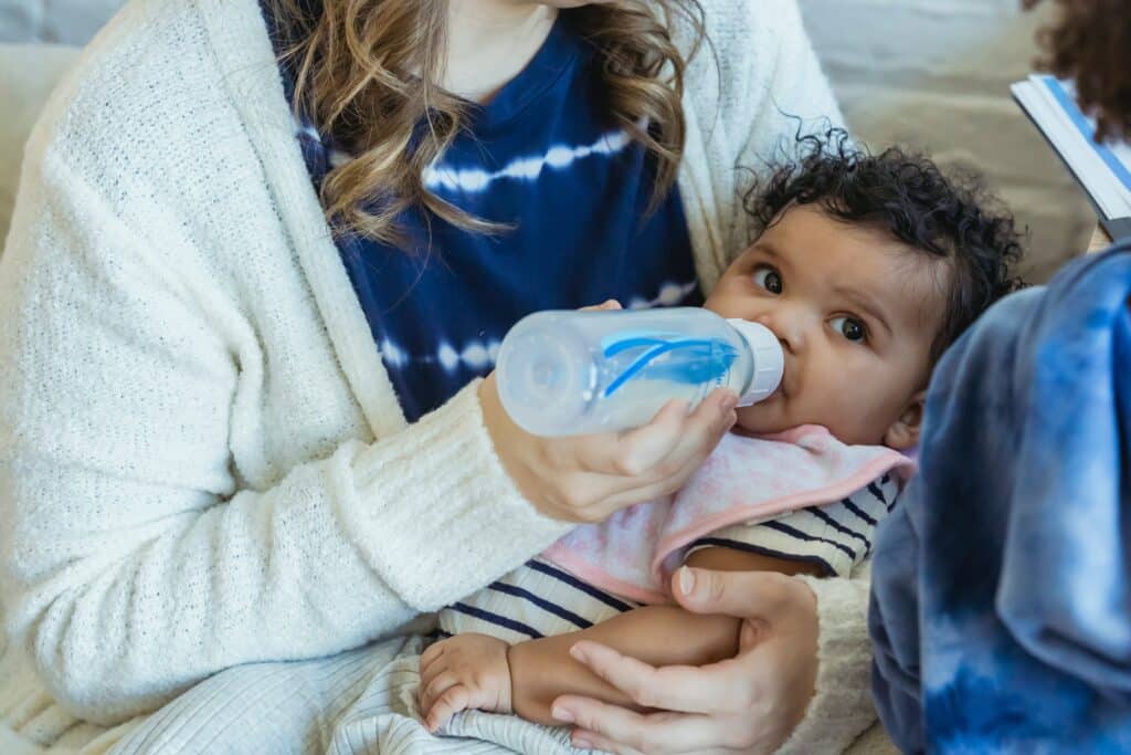 Baby looking around while drinking a bottle