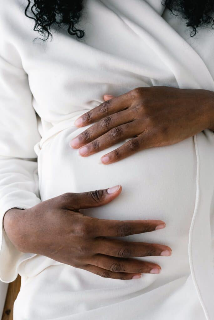 Pregnant person caressing her abdomen