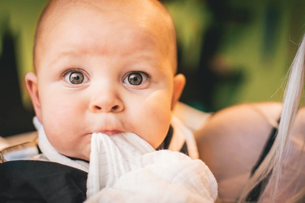 Baby with baby wipes in mouth