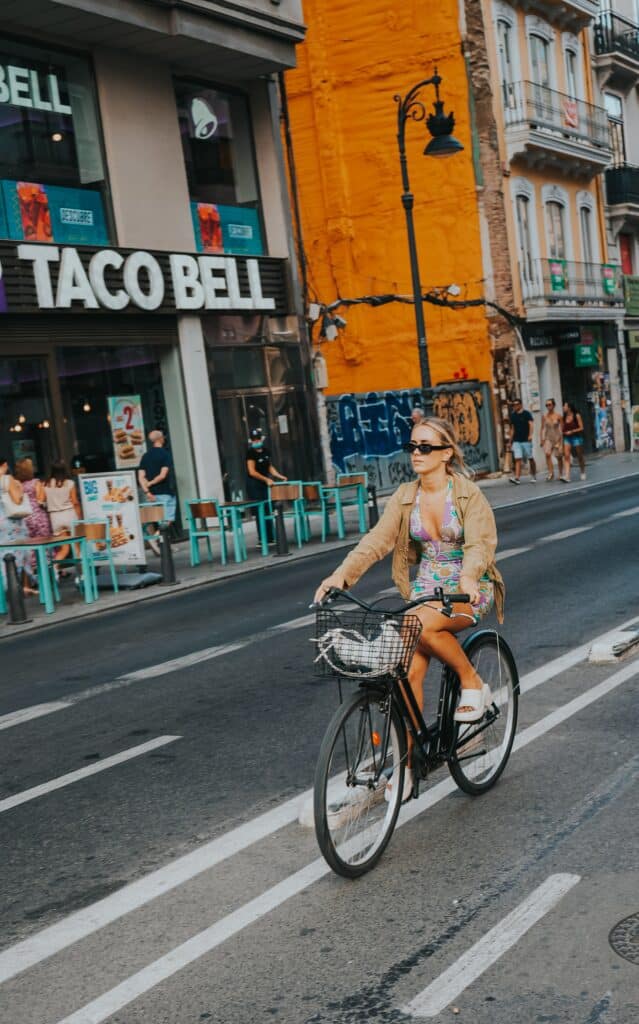 Woman rides a bicycle outside of Taco Bell