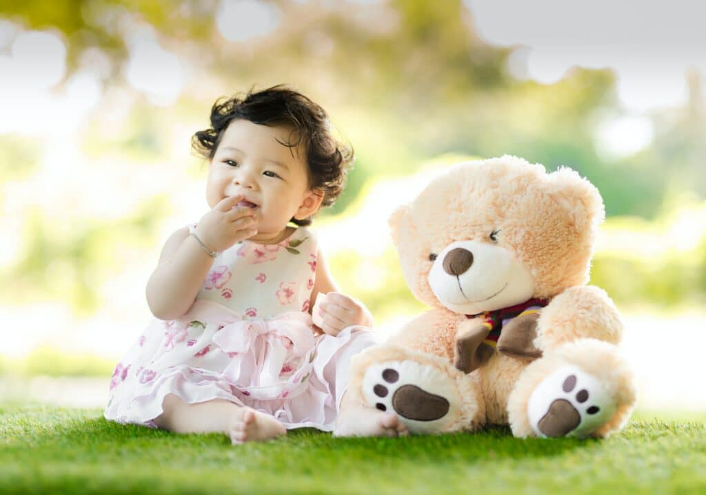 Baby girl sitting with teddy bear