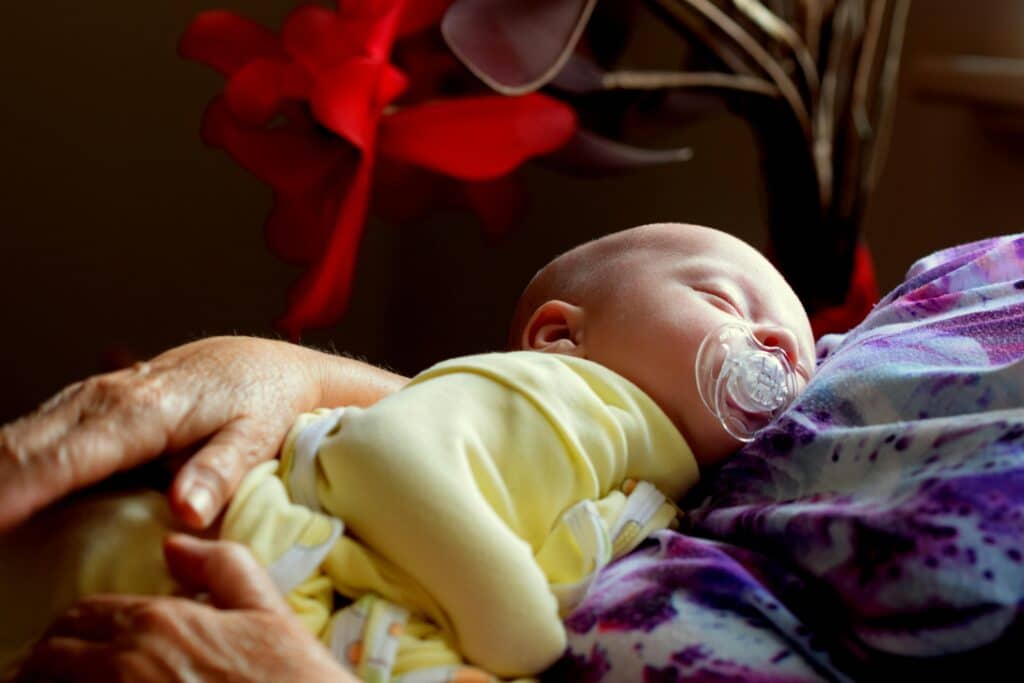 baby sleeping in grandmother's arms