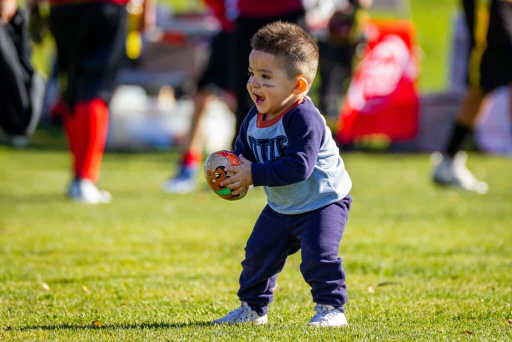 Taking a baby to a sporting event can help get them interested in playing a sport themselves!